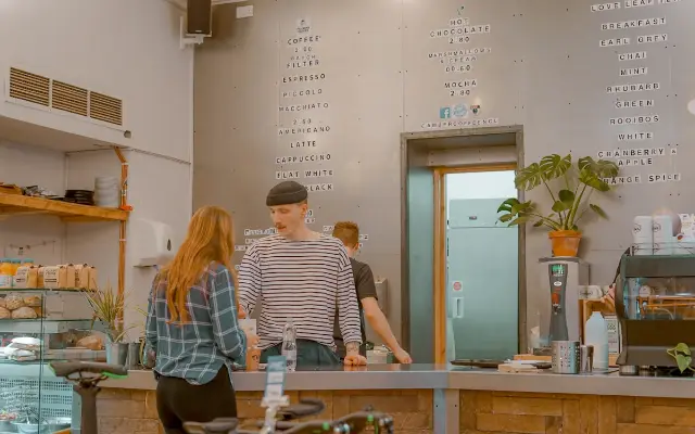 Customers at the counter of a neighbourhood café.