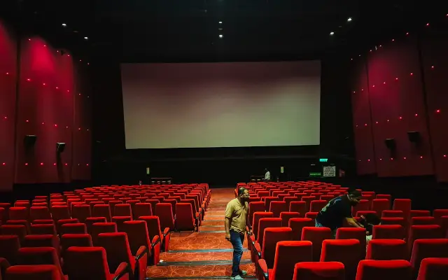 Rows of red seats in a cinema auditorium.