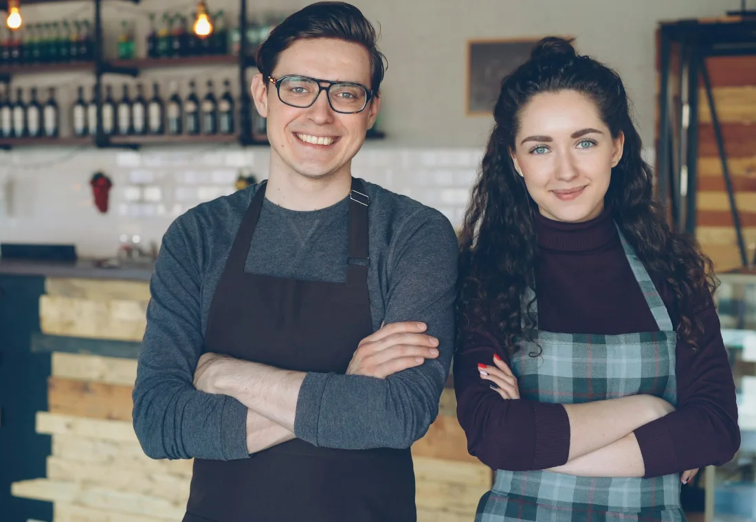 Two local cafe owners standing together in their shop