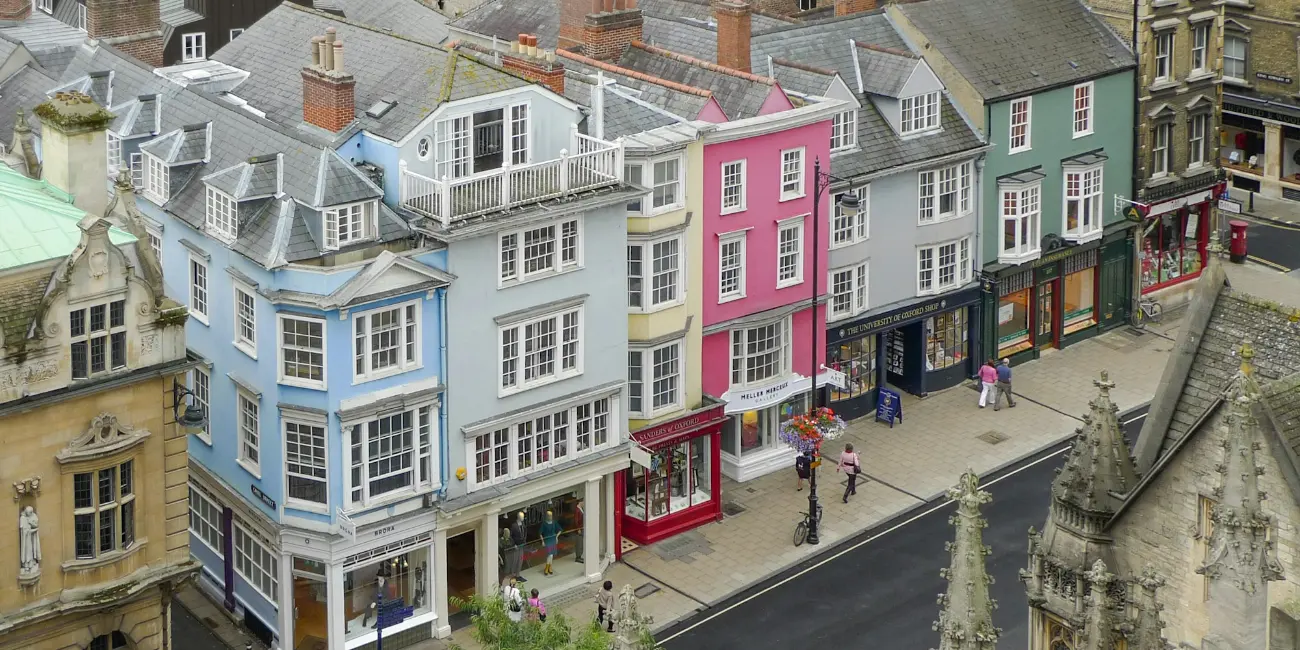 A row of pastel-painted shopfronts along a historic high street.