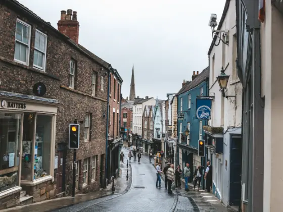 Shoppers walking along a street of independent shops.