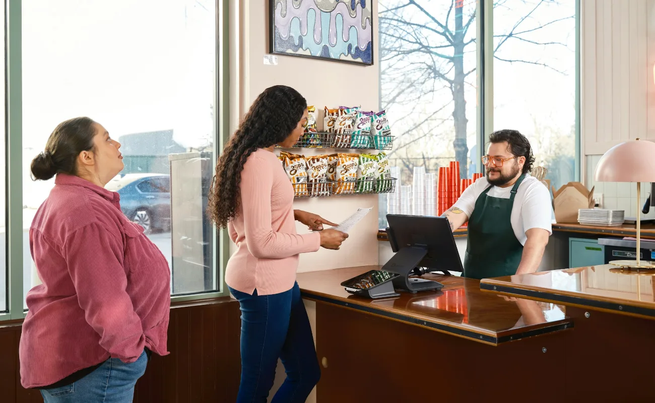 A customer ordering at the counter of a local eatery